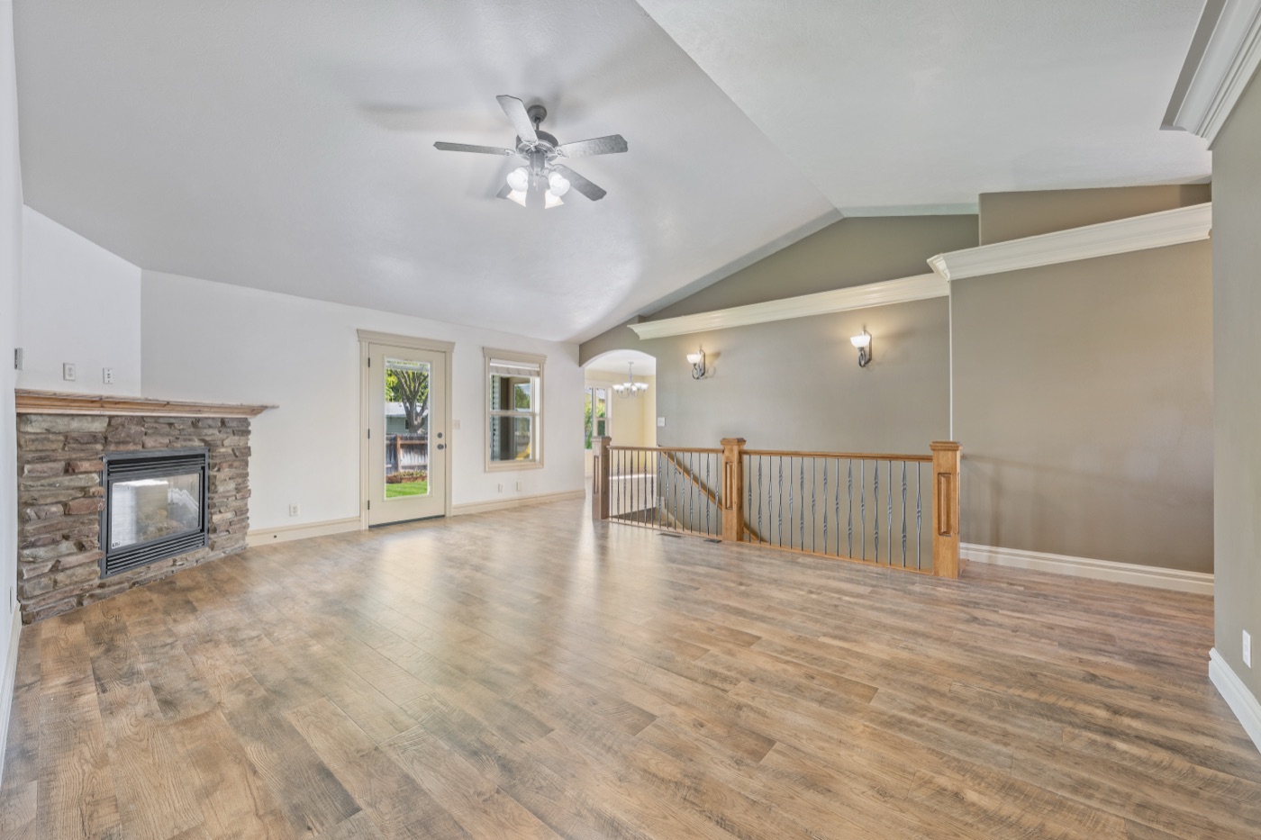 Open vaulted living room with stone fireplace